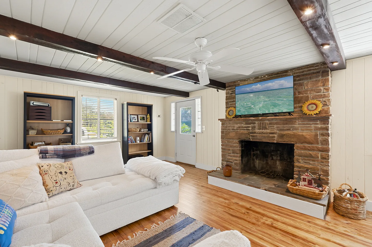 Living room with stone fireplace and wood beams